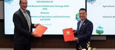 ACIAR and Vietnam Ministry of Agriculture and Environment representatives exchange signed research collaboration documents in Canberra.