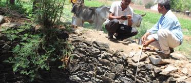 Men kneeling beside a well