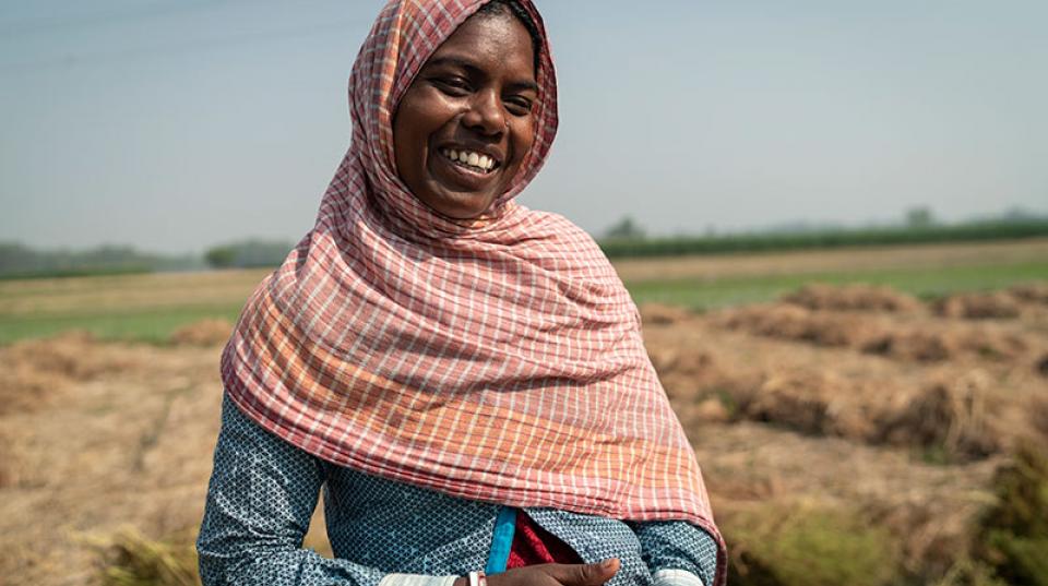 A woman with headscarf standing in a field