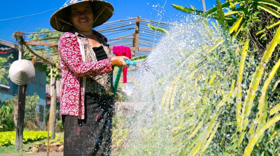 Mrs. Pheng waters her garden in Ekxang Village (Photo: Madeline Dahm)