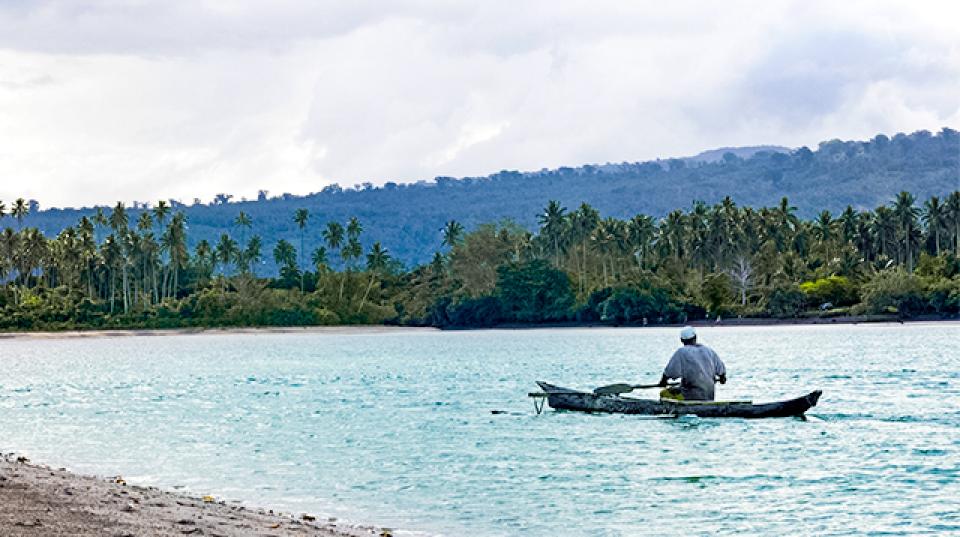 A fisherman paddles out of an inlet in Samoa