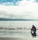 a fisherman sitting on the sea shore