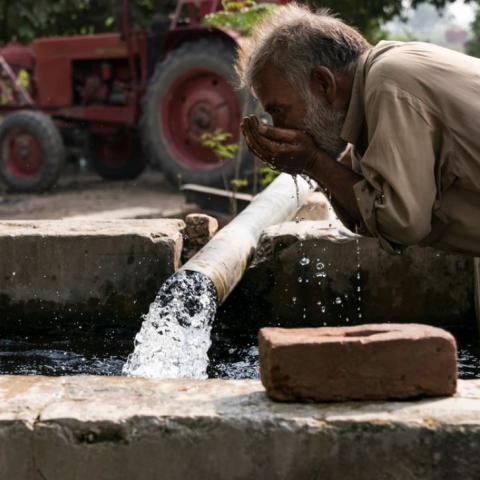 man drinking from well