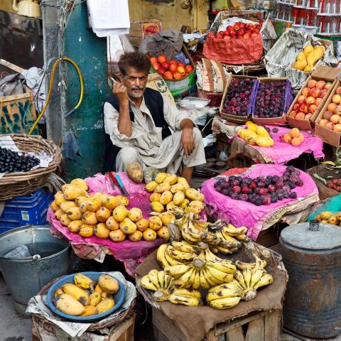 Man surrounded by fruit in a Pakistan market