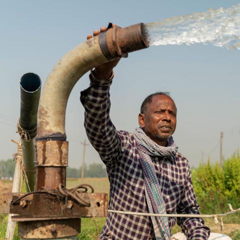 Man holding onto large water pump