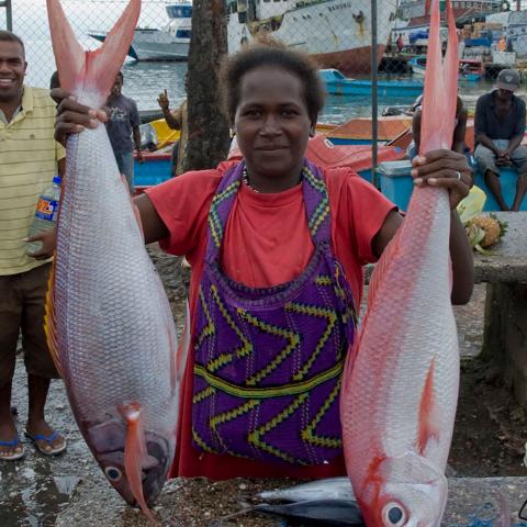 Woman holding up two large fish