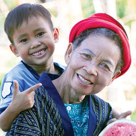 Lady with a child on her back holding fruit