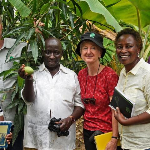 Group of people smiling and standing in front of trees