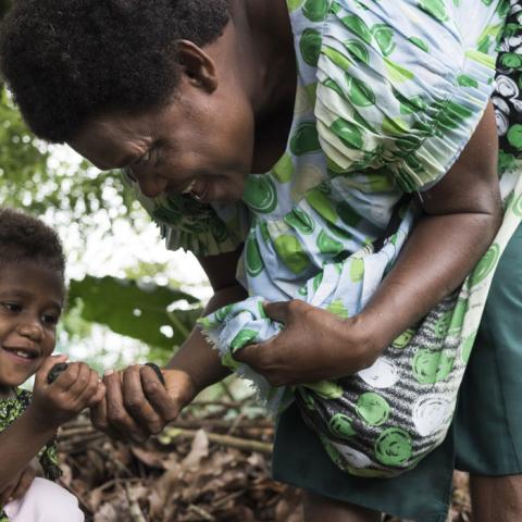 Woman and child collecting nuts in forest