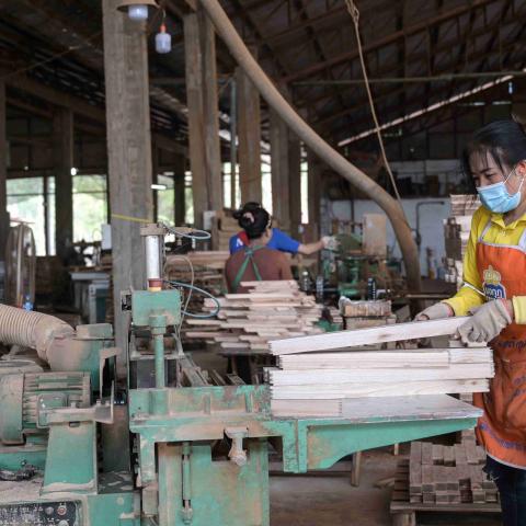 A worker at Burapha cutting wood