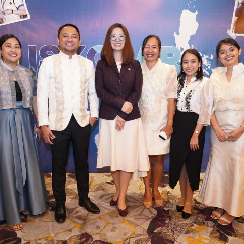 A group of people standing and smiling for a photo. 
