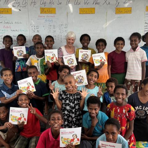Children in a classroom holding picture books