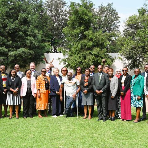 Group photo of event participants standing on a lawn