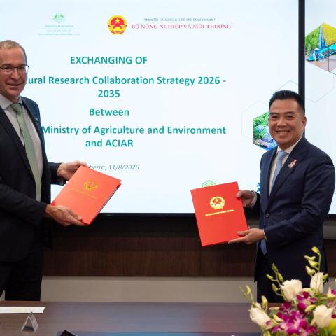 ACIAR and Vietnam Ministry of Agriculture and Environment representatives exchange signed research collaboration documents in Canberra.
