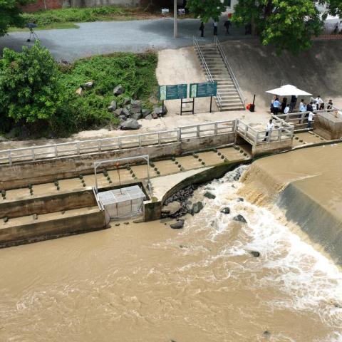 Aerial view of a water control structure and fish passage facility on a river channel.