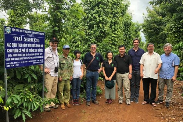 group of people smiling at camera beside sign