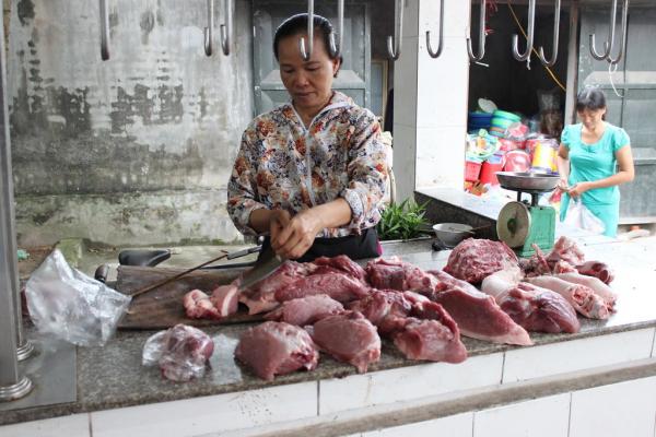 woman preparing meat at market