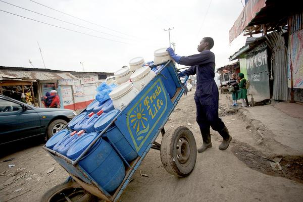 Samson Owino, waste management operator, collects waste in Mukuru, Nairobi. Credit: Sanergy