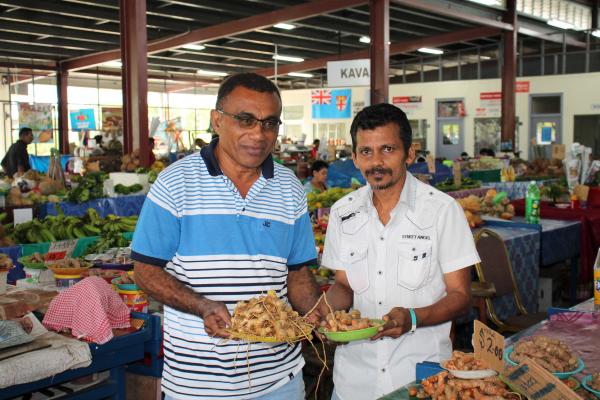 Maika at local market talking to farmers about the use of NFTP products such as wild tumeric as an alternative source of income