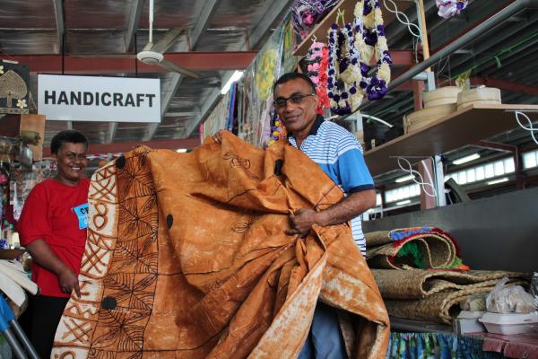 Maika holds masi with a market seller.