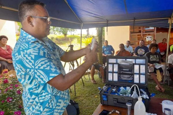 Man in blua shirt demonstrates soil testing technique