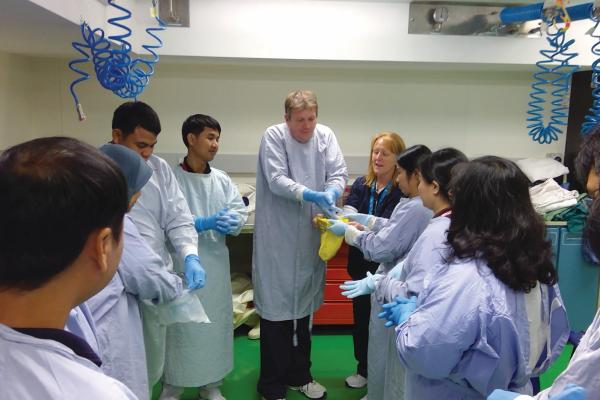 group of people putting on gloves and ppe to prevent spreading disease
