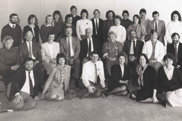 A black-and-white group photo of about 30 men and women in business atire.