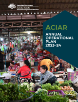 An undercover market place, with rows of vegetables in the foreground and people working at stalls in the mid view.