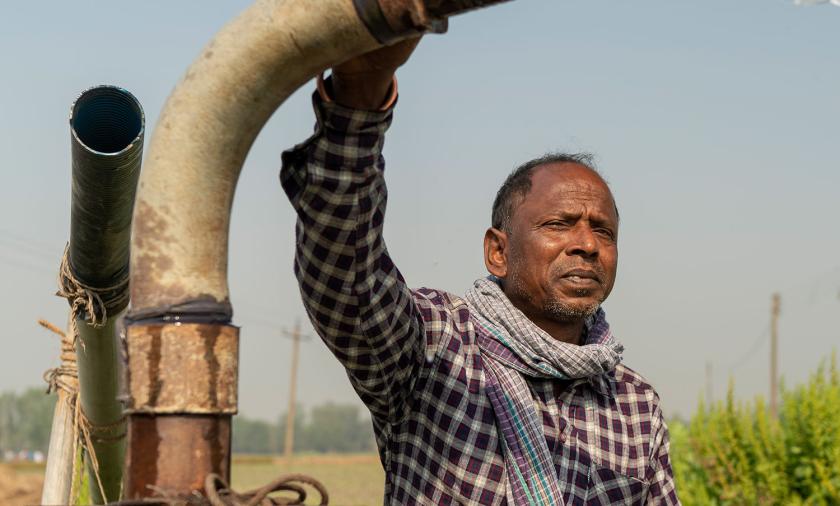 Man holding onto large water pump