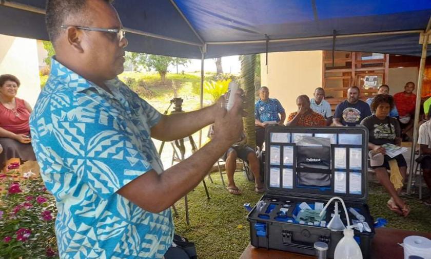Man in blua shirt demonstrates soil testing technique