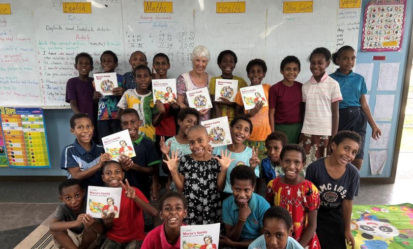Children in a classroom holding picture books